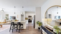 Located at 1001 Sundial Cir in Sneads Ferry, NC, this thoughtfully designed 2-bedroom, 2-bathroom single-floor residence offers a comfortable and modern living experience. The open-concept kitchen is a standout feature, showcasing white shaker cabinetry, granite countertops, a tile backsplash, stainless steel appliances including a French door refrigerator and range, and a kitchen island with pendant lighting and bar seating — ideal for both everyday cooking and entertaining. Wood-look flooring flows through the main living areas, adding warmth and cohesion throughout. The living room is bright and inviting, featuring a ceiling fan and sliding glass door access to a private balcony with outdoor views. The primary bedroom offers plush carpeting, large windows with natural light, and a bold accent wall, accompanied by an en suite bathroom with a granite vanity and glass-enclosed walk-in shower. The second bedroom features a soothing color palette, ceiling fan, and ample space. A second full bathroom includes a soaking tub with shower. Additional highlights include a spacious walk-in closet with wire shelving and a dedicated in-unit laundry area with a full-size washer and dryer.