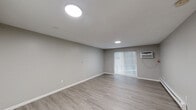 Located at 357 Newport Ave in Quincy, MA, this one-bedroom, one-bathroom residence offers a thoughtfully arranged single-floor layout with consistent modern finishes throughout. Light-toned hardwood-style flooring flows seamlessly across every room, creating a clean and cohesive aesthetic.

The kitchen is well-equipped with warm honey-toned cabinetry providing ample upper and lower storage, granite-style countertops, a black gas range, refrigerator, and a double-basin sink. A peninsula counter separates the kitchen from the rest of the living area, offering additional prep space. The kitchen opens directly into the living room, which is bright and airy, featuring recessed lighting, a wall-mounted air conditioning unit, and a sliding glass door framed by vertical blinds that invites natural light and outdoor access.

The bedroom is a generously sized private retreat with dual bi-fold closets, a recessed ceiling light, a baseboard heater, and a window for natural light. The bathroom features a full tub-shower combination, a white vanity with a single-basin sink, a wall-mounted mirror cabinet, a chrome light fixture, and white mosaic tile wainscoting, all contributing to a clean, functional design. The unit also includes baseboard heating and efficient use of its compact yet comfortable footprint.
