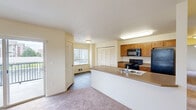 Located on W Hildebrand Blvd in Kennewick, Washington, this 2-bedroom, 1-bathroom residence offers a practical and well-designed single-floor layout. The open-concept living and kitchen area forms the heart of the home, where wood-look flooring flows through the kitchen and transitions to plush carpeting in the living room. The kitchen is equipped with warm-toned wood cabinetry, black appliances including a range, microwave, and refrigerator, and a peninsula with a built-in sink that provides additional prep and seating space. The living room is bright and airy, with a sliding glass door that opens to a private balcony, filling the space with natural light and offering outdoor views. The spacious primary bedroom features a ceiling fan, a large window with vertical blinds, and a closet, creating a comfortable and functional retreat. The second bedroom is similarly appointed with carpeted floors and a window overlooking the exterior. The full bathroom includes a wood-vanity with ample drawer storage, a large mirror with overhead lighting, and a full tub-shower combination set on hardwood-style flooring. Additional storage is provided by a dedicated closet. The overall palette of warm neutral tones gives the home a clean, welcoming ambiance throughout.
