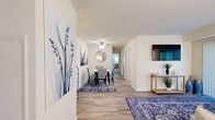 Located at 102 Waldon Rd in Abingdon, Maryland, this two-bedroom, two-bathroom residence offers a well-designed single-floor layout with a comfortable and functional living environment. Wood-look flooring flows throughout the space, complementing the neutral, warm-toned walls that lend a clean and inviting ambiance.

The living room is a welcoming gathering space featuring wall-mounted lighting, a sliding glass door with vertical blinds that allows natural light to pour in, and generous room for seating. The kitchen is efficiently laid out in a U-shape configuration, featuring light wood cabinetry, gray countertops, white appliances including a coil-top range and built-in microwave, and a window above the sink for added natural light.

The spacious primary bedroom accommodates a queen-sized bed with ease and includes a window with decorative curtains. The second bedroom features bunk-bed-friendly dimensions, a built-in closet with louvered doors, and direct access to one of the bathrooms. Both bathrooms are finished with warm wood vanities, bright vanity lighting, and tub-shower combinations.

The building exterior is set within a well-maintained, tree-lined property with open green space, providing a peaceful residential setting.
