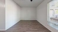 Located at 400 Kenniston Dr in Austin, TX, this efficiently designed studio unit offers a well-organized single-floor layout that maximizes every square foot. The kitchen is a standout feature, outfitted with white shaker-style cabinetry, granite-look countertops, stainless steel appliances including an electric range, over-the-range microwave, and a full-size refrigerator. Open shelving adds accessible storage, while durable wood-look flooring runs throughout the entire unit, providing a cohesive and low-maintenance aesthetic. The combined kitchen and living area flows openly, anchored by a ceiling fan that enhances air circulation. A large window with blinds invites natural light into the living space while offering views of the surrounding greenery, creating a bright and airy atmosphere. The bathroom is clean and functional, featuring a vessel sink set atop a granite-look vanity, a mirrored wall, and wood-look flooring consistent with the rest of the unit. A dedicated closet provides convenient storage. The unit's crisp white walls and neutral palette create a versatile and move-in-ready environment, ideal for those seeking a practical and well-appointed living space in Austin.
