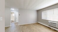 Located at 5265 E 126th St in Garfield Heights, Ohio, this one-bedroom, one-bathroom unit offers a thoughtfully organized single-floor layout. Light wood-toned luxury vinyl flooring runs throughout the space, complementing the neutral gray walls and crisp white trim to create a clean, cohesive aesthetic.

The living area is open and well-lit, with windows fitted with blinds allowing natural light to fill the room. A baseboard heating system and a window air conditioning unit provide year-round climate control. The hallway connects the main living spaces efficiently, with three closets offering generous storage.

The galley-style kitchen is compact yet functional, featuring stainless steel appliances including a full-size refrigerator and a gas range, white cabinetry, butcher block countertops, and subway tile accents — a practical and stylish setup for everyday cooking. An adjacent dining area provides space for meals.

The bedroom is a comfortable, well-proportioned room with a window that brings in natural light and a baseboard heater along the wall. The bathroom includes a full tub and shower combination surrounded by classic white subway tile, with a window providing ventilation. The overall ambiance is clean, simple, and move-in ready.