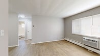 Located at 5265 E 126th St in Garfield Heights, Ohio, this one-bedroom, one-bathroom unit offers a thoughtfully organized single-floor layout. Light wood-toned luxury vinyl flooring runs throughout the space, complementing the neutral gray walls and crisp white trim to create a clean, cohesive aesthetic.

The living area is open and well-lit, with windows fitted with blinds allowing natural light to fill the room. A baseboard heating system and a window air conditioning unit provide year-round climate control. The hallway connects the main living spaces efficiently, with three closets offering generous storage.

The galley-style kitchen is compact yet functional, featuring stainless steel appliances including a full-size refrigerator and a gas range, white cabinetry, butcher block countertops, and subway tile accents — a practical and stylish setup for everyday cooking. An adjacent dining area provides space for meals.

The bedroom is a comfortable, well-proportioned room with a window that brings in natural light and a baseboard heater along the wall. The bathroom includes a full tub and shower combination surrounded by classic white subway tile, with a window providing ventilation. The overall ambiance is clean, simple, and move-in ready.