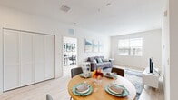 Located at 1401 Davenport Blvd in Davenport, FL, this well-appointed 2-bedroom, 2-bathroom residence offers a clean, modern aesthetic across a single thoughtfully designed floor. Light wood-style flooring flows throughout, complementing the bright white walls and recessed lighting that give the space an open, airy feel.

The kitchen serves as a functional centerpiece, featuring white shaker cabinetry, granite countertops, stainless steel appliances — including a refrigerator, range, microwave, and dishwasher — and a peninsula with bar seating. It opens directly to the dining area and living room, creating a seamless open-concept layout ideal for entertaining. The living room is filled with natural light from large windows fitted with blinds, offering a comfortable and welcoming atmosphere.

The primary bedroom is generously sized, with a large window, ample closet space, and room for a dedicated workspace. The second bedroom also benefits from natural light and offers versatile use. Three closets provide excellent storage throughout the unit. Both bathrooms maintain the clean, modern design of the home, with one featuring a full tub-shower combo with white subway tile surround and granite-topped vanity. The overall ambiance is bright, contemporary, and move-in ready.
