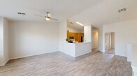 Located at 647 West Baseline Road in Tempe, Arizona, this two-story home offers three bedrooms and three bathrooms across two well-organized floors. The ground floor hosts the main living areas, where an open-concept layout connects the living room and kitchen. The kitchen is equipped with warm honey-toned wood cabinetry, stainless steel appliances including a refrigerator, range, and microwave, and a peninsula counter that separates it from the living space. Light-toned luxury vinyl plank flooring and a ceiling fan complete the bright, airy atmosphere of the main level. A carpeted staircase with a wood handrail leads to the upper floor, which contains all three bedrooms. The primary bedroom is a well-proportioned space featuring plush carpet, a ceiling fan, and sliding glass doors that open to an outdoor area. The en-suite bathroom includes a single vanity with wood cabinetry, white countertop, and a glass-enclosed walk-in shower. The additional bedrooms are carpeted, naturally lit with windows fitted with blinds, and each equipped with a ceiling fan. The three bathrooms are clean and functional, maintaining a consistent neutral palette with wood-toned vanities throughout. The home's overall aesthetic is bright and modern, with white walls and consistent finishes across all rooms.