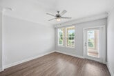 This 1,110-square-foot single-floor residence at 2015 Wave Crest Drive in Brentwood, NC features a thoughtfully designed layout with 2 bedrooms, 3 bathrooms, and 2 closets. The open-concept kitchen serves as the heart of the home, showcasing dark espresso cabinetry with brushed nickel hardware, granite countertops, stainless steel appliances, and a central island with pendant lighting and bar-height seating. Light wood-look luxury vinyl plank flooring flows throughout the main living areas, complemented by crown molding and recessed lighting. The primary bedroom measures 170 square feet and is filled with natural light from a bank of large windows, and features plush carpet and a ceiling fan. The primary bathroom includes a double-sink vanity with granite countertops, dark wood cabinetry, and a glass-enclosed shower. The second bedroom also offers generous natural light, plush carpeting, a ceiling fan, and access to a dedicated closet. Each bathroom maintains a consistent, refined aesthetic with granite counters and wood cabinetry. The dedicated laundry room includes a full-size washer and dryer with overhead dark wood cabinetry for additional storage. Built-in shelving in the living area adds functional display space throughout this well-appointed home.