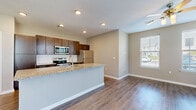 Located at 9641 N Ambassador Dr in Kansas City, MO, this single-floor, 2-bedroom, 2-bathroom residence offers a thoughtfully designed layout with contemporary finishes throughout. The open-concept kitchen and living area serves as the heart of the home, featuring warm wood-tone cabinetry, granite countertops, a center island with a sink, stainless steel appliances including a refrigerator, range, and microwave, and a classic white subway tile backsplash. Wood-style flooring runs through the main living areas, while a ceiling fan and multiple windows flood the space with natural light and outdoor views. The spacious living area is bright and airy, with a clean, neutral palette that complements any décor. Both bedrooms are carpeted for comfort and include dedicated closets. The primary bedroom is generously sized and connects to an en-suite bathroom equipped with dark wood cabinetry, granite countertops, and a soaking tub. The second bathroom mirrors the same refined finishes, offering a tiled tub-shower combination and matching vanity details. Two closets provide ample storage throughout the residence. The overall ambiance is modern, clean, and functional, making for a comfortable and stylish living environment.