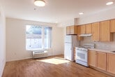 Located at 1701 W El Camino Real in Mountain View, California, this efficiently designed single-floor unit offers a well-organized layout that makes smart use of its compact footprint. Light hardwood flooring runs continuously throughout the space, creating a cohesive and bright interior.

The living area is open and airy, bathed in natural light from a large window that also provides views of the surrounding neighborhood. A wall-mounted HVAC unit ensures year-round climate control, and clean white walls contribute to the space's fresh, minimalist aesthetic.

The kitchen is thoughtfully appointed with warm wood cabinetry extending to the upper walls, offering generous storage. White appliances — including a refrigerator, electric range, and under-cabinet range hood — are integrated alongside a single-basin sink, all set against light countertops. Recessed lighting overhead enhances both functionality and ambiance.

A dedicated hallway leads to the bathroom, which features a wood-cabinet vanity with a mirror, a combination tub and shower with a handheld showerhead, and neutral tile flooring. A closet provides additional storage within the unit.

The overall design is clean, functional, and well-lit — ideal for those seeking a practical living space in a prime Mountain View location along the El Camino Real corridor.