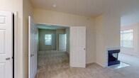 This single-floor residence offers a thoughtfully laid-out interior with a neutral color palette and a mix of flooring materials throughout. The kitchen serves as a functional centerpiece, finished with light wood cabinetry, white countertops, and a full suite of stainless steel appliances including a gas range, built-in microwave, dishwasher, and refrigerator. A skylight overhead brightens the space naturally, while wood-style flooring adds warmth underfoot.

The living areas are carpeted in a neutral tone and receive generous natural light through multiple windows fitted with horizontal blinds. The open layout connects rooms fluidly, creating a cohesive and comfortable flow throughout the unit. A tiled accent wall is visible in one of the rooms, adding a subtle design detail.

The bedroom is spacious and carpeted, featuring access to a large walk-in closet equipped with multi-tiered wire shelving systems that provide ample storage. The bathroom includes a wood-toned vanity with a white countertop, light wood-style flooring, a tub-shower combination, and a grab bar for added convenience. Clean white trim and doors throughout the unit contribute to a consistent, well-maintained aesthetic.
