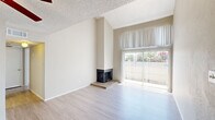 This two-bedroom, two-bathroom home is thoughtfully arranged across two floors, offering a functional and comfortable layout. The main level features a spacious living area with vaulted ceilings that create an open, airy atmosphere. A corner fireplace serves as a focal point, while large sliding glass doors flood the room with natural light and provide outdoor views. Light-toned laminate flooring runs throughout the main living areas, complementing the neutral, warm wall tones. The kitchen features speckled granite-style countertops, ample cabinetry, and efficient use of space. Two full bathrooms are included, each equipped with a shower-tub combination, overhead cabinetry, and speckled countertop vanities with large mirrors. The bedrooms offer comfortable proportions, with the primary bedroom situated on the upper floor, featuring plush carpeting, a ceiling fan, a closet, and a window with vertical blinds for natural light. The second bedroom is located on the main floor and also benefits from natural light via a large window. Textured ceilings are present throughout, and the home includes four hallways and two closets for added storage. The overall ambiance is clean, bright, and move-in ready, with a neutral palette that suits a variety of interior styles.