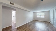 Located at 700 E 100th Terrace in Kansas City, MO, this single-floor, 3-bedroom, 1-bathroom home offers a practical and well-organized layout. Wood-look luxury vinyl flooring runs consistently throughout the home, complemented by neutral gray and beige tones that create a clean, cohesive aesthetic.

The living room is a generous open area featuring a textured ceiling, HVAC vents for year-round comfort, and a window that allows natural light to fill the space. Each of the three bedrooms is equipped with wood-look flooring, windows with blinds, and ceiling fans with light fixtures in select rooms for added functionality. The primary bedroom includes access to a dedicated closet, providing useful storage.

The galley-style kitchen is efficiently designed with white cabinetry featuring black hardware, stainless steel appliances including a refrigerator, over-the-range microwave, and electric range, along with a subway tile backsplash and ample counter space.

The full bathroom is finished in a crisp white palette with a vanity featuring white cabinetry and black fixtures, a tub/shower combination, and wood-look flooring that ties the room together. A hallway connects the primary rooms, keeping the floorplan organized and easy to navigate throughout.