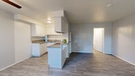 Located at 841 W La Habra Blvd in La Habra, California, this well-appointed one-bedroom, one-bathroom unit offers a thoughtfully designed layout across a single floor. The open-concept living and kitchen area creates a bright, airy feel, with large windows allowing natural light to fill the space. Sliding doors lead to a private patio, adding an inviting outdoor extension to the living area. The kitchen is a functional highlight, featuring crisp white cabinetry, granite-style countertops, a gas range, and a peninsula that seamlessly connects to the living area — ideal for both cooking and casual dining. Durable hardwood-style flooring flows throughout the main living spaces, while the bedroom features warm, plush carpeting underfoot. The generously sized primary bedroom includes a ceiling fan, a sliding-door closet with built-in shelving, and ample room for furnishings. A hallway connects the living areas to the full bathroom, which is finished with a granite vanity countertop, a tub/shower combination, and a frosted window for natural light and privacy. The overall palette of soft grays and crisp whites gives the space a clean, modern ambiance throughout.