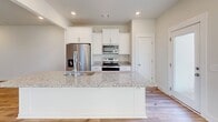 Located at 214 Pine Breeze Way in Greenville, SC, this two-story home offers a clean, modern design with consistent light-toned hardwood flooring throughout. The open living area on the main floor is bright and spacious, featuring recessed lighting, neutral walls, and a seamless flow into the kitchen. The kitchen is well-appointed with white shaker-style cabinetry, granite countertops, stainless steel appliances including a refrigerator, electric range, and over-the-range microwave, plus convenient pantry access. A light-filled hallway with recessed lighting and paneled white doors connects the main-floor rooms efficiently. The upper level hosts generously sized bedrooms, each benefiting from natural light via multiple windows with blinds and ceiling fans for added comfort. The primary bathroom features a wide vanity with white countertops, ample cabinetry, wood-look flooring, and a separate water closet. Additional bathrooms include a full tub-shower combo with built-in corner shelving. The attached garage provides substantial storage and parking space with an automatic opener. Throughout, the home maintains a cohesive, neutral color palette that enhances its bright, move-in-ready atmosphere.