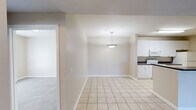 Located at 3090 Alabama River Parkway in Montgomery, Alabama, this single-story home offers three bedrooms and two bathrooms across a well-designed, comfortable floor plan. The open-concept living room and kitchen area forms the heart of the home, featuring plush neutral carpeting, a ceiling fan with light fixture, and a pass-through kitchen counter that connects the two spaces seamlessly. French doors in the living room invite natural light and provide outdoor access. The kitchen is equipped with white cabinetry, dark countertops, tile flooring, and white appliances including a range, microwave, dishwasher, and refrigerator. The spacious primary bedroom offers generous proportions with soft carpeting and access to a well-appointed bathroom featuring a wide vanity with ample cabinetry, a large mirror, hardwood-style flooring, and bright vanity lighting. The secondary bathroom includes a tiled tub-shower combo and matching hardwood-style floors. Additional bedrooms are carpeted with large windows that frame outdoor greenery. Closets throughout the home feature wire shelving systems for organized storage. Warm neutral tones and clean white trim create a cohesive, move-in-ready aesthetic throughout the entire residence.