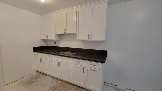 Kitchen immediately after cabinets installed. Check back for updated photos. - 14428 Amar Rd