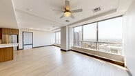 Located in the heart of Dallas at 1400 Pacific Ave, this high-rise residence offers an impressive combination of modern design and urban luxury. The expansive open-concept living and kitchen area is anchored by large floor-to-ceiling windows that flood the space with natural light and frame sweeping panoramic views of the Dallas skyline. Light hardwood flooring flows throughout the main living areas, complementing the clean, neutral palette.

The gourmet kitchen is a standout feature, boasting rich warm-toned cabinetry, stainless steel appliances including a built-in microwave and refrigerator, and a generous center island with a stone countertop — ideal for both cooking and entertaining.

The two bedrooms are well-proportioned, with plush carpeting, ceiling fans, and access to city views. The spacious primary bedroom includes a walk-in closet with built-in shelving and dedicated clothing rods. Six bathrooms are finished with neutral tile flooring, built-in cabinetry, and glass-enclosed shower areas, with some bathrooms offering direct skyline views. A dedicated laundry room houses a full-size washer and dryer. Dark-trimmed panel doors and rich baseboards tie together the refined aesthetic throughout this thoughtfully designed urban residence.