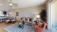 Located at 1630 Paseo Monti in Chula Vista, this thoughtfully designed 3-floor model home showcases a contemporary aesthetic with high-quality finishes throughout. The open-concept kitchen is a standout feature, equipped with stainless steel appliances including a gas range, microwave, and refrigerator, complemented by rich dark cabinetry, a marble-style backsplash, and sleek light quartz countertops that extend to a generous breakfast bar with pendant lighting. Wood-look flooring flows through the main living areas, adding warmth and cohesion to the design. The spacious living room is bright and welcoming, featuring a ceiling fan, neutral tones, and sliding glass doors that open to a private balcony overlooking scenic hillside and neighborhood views. Bedrooms offer plush carpeting and ample natural light; the primary bedroom includes direct balcony access through floor-to-ceiling sliding doors with expansive outdoor views. Bathrooms are finished with dark wood vanities, white quartz countertops, framed mirrors, and wood-look flooring. The primary bath features a dual-sink vanity and a soaking tub with shower. A dedicated in-unit laundry room with side-by-side washer and dryer adds everyday convenience. A staircase connects all three levels, providing a well-organized and functional multi-floor layout throughout the home.