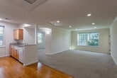 Located at 604 S Fair Oaks Ave in Sunnyvale, California, this well-appointed two-bedroom, one-bathroom residence offers a comfortable and functional single-floor layout. The open-concept living and kitchen area forms the heart of the home, where a breakfast bar with granite-style countertops connects the two spaces seamlessly. The kitchen is equipped with warm wood cabinetry, a full suite of white appliances including a refrigerator, range, microwave, and dishwasher, complemented by hardwood-style flooring and a window that brings in natural light. The spacious living room features plush carpeting, recessed lighting, crown molding, and a large window with leafy outdoor views, creating a bright and welcoming atmosphere. Both bedrooms are carpeted and well-lit with natural light from generously sized windows; the primary bedroom offers ample space and closet storage. The bathroom is finished with granite-style surfaces, a combined tub and shower with a stone-surround enclosure, and a wood-toned vanity. A private balcony enclosed with horizontal wood paneling provides a quiet outdoor retreat with views of surrounding greenery, completing this comfortable Sunnyvale residence.