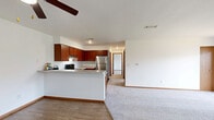 Located at 3405 Logan Dr in Oshkosh, Wisconsin, this well-appointed 2-bedroom, 1-bathroom home offers a functional and comfortable single-floor layout. The open-concept design seamlessly connects the kitchen and living area, creating an inviting communal space. The kitchen is a standout feature, equipped with rich cherry wood cabinetry, stainless steel appliances including a refrigerator and range, a peninsula with a countertop overhang ideal for casual dining, and durable wood-style flooring. The living area flows naturally from the kitchen, offering plush carpeting underfoot and access to a private balcony through sliding glass doors that bring in generous natural light. Both bedrooms are carpeted and bright, each featuring windows with outdoor views and ample wall space. The primary bedroom includes access to a dedicated closet and a nearby full bathroom. The bathroom is finished with tile flooring, a single-sink vanity with matching cabinetry, and a full tub-shower combination. Throughout the home, warm wood-tone door frames and trim provide a cohesive aesthetic against the clean white walls, resulting in a bright and practical living environment.