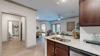 Located at 2151 Prairie Dr in Prosper, TX, this well-appointed one-bedroom, one-bathroom residence offers a thoughtfully designed single-level floor plan. The open-concept living area seamlessly connects the living room, dining space, and kitchen, creating a bright and cohesive environment. Wood-look flooring flows throughout the main living areas, complemented by crown molding and ceiling fans that add a refined touch. The living room features a sliding glass door that welcomes natural light and provides access to an outdoor balcony area.

The kitchen is a standout feature, boasting rich dark-wood cabinetry, granite countertops, a center island with a double-basin sink, and a full suite of stainless steel appliances, including a French door refrigerator, range, microwave, and dishwasher. The dining area sits adjacent, creating an ideal layout for everyday living and entertaining.

The spacious primary bedroom is finished with plush carpet, large windows for natural light, and a ceiling fan. Three closets provide generous storage throughout the unit. The bathroom mirrors the kitchen's design aesthetic with dark cabinetry and granite countertops. A dedicated laundry area completes this efficient and comfortable residence.