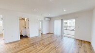 Located at 1185 Myra Ave in Los Angeles, this thoughtfully designed 2-bedroom, 2-bathroom residence offers a clean, modern aesthetic throughout. Light wood-tone flooring flows seamlessly across the entire unit, complementing the crisp white walls and recessed lighting that create a bright, welcoming atmosphere.

The open-plan living and dining area is generously proportioned, anchored by a wall-mounted mini-split system for year-round comfort and sliding glass doors that lead to a private balcony, filling the space with natural light and outdoor views. A stacked in-unit washer and dryer is conveniently integrated near the main living area.

The galley-style kitchen is well-appointed with white shaker cabinetry, black hardware accents, stainless steel appliances including a gas range, dishwasher, and built-in microwave, plus a subway tile backsplash and ample counter space.

Both bedrooms are well-sized with clean white walls, wood flooring, and dedicated closets. The second bedroom benefits from a wide window with neighborhood views. Both bathrooms feature a consistent design language: white subway tile walls, hexagonal dark tile flooring, white vanities with black fixtures, and soaking tub-shower combinations. The overall ambiance is clean, contemporary, and move-in ready.