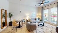 Located at 1027 Ashes Dr in Wilmington, NC, this single-floor residence offers a thoughtfully designed open-concept layout with contemporary finishes and a warm, inviting ambiance. The living and dining area serves as the heart of the home, featuring light hardwood-style flooring, a ceiling fan, and pendant lighting that complement the neutral color palette. A cozy seating arrangement anchors the space, which flows seamlessly into the dining area and kitchen. The kitchen is well-equipped with stainless steel appliances, including a side-by-side refrigerator, range, and built-in microwave, all framed by sleek gray cabinetry and a granite-topped breakfast bar with seating. The bedrooms are carpeted and filled with natural light from large windows with stylish drapery. Each bedroom offers a serene retreat with ample space and a clean, modern aesthetic. The bathroom features large-format tile flooring, a full tub-shower combination, and a clean, functional layout. Throughout the residence, high ceilings enhance the sense of openness, while the consistent use of neutral tones and quality materials creates a cohesive and polished living environment.