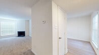 This single-floor residence offers a clean, neutral aesthetic throughout, with white walls and light-toned finishes creating a bright and cohesive atmosphere. The entryway leads into the main living area, which features plush carpeting, recessed lighting, and a fireplace, lending a comfortable and inviting ambiance. Built-in shelving and a cabinet nook add practical storage and display options to the living space, while a closet with double doors provides additional organization.

The kitchen is efficiently designed with white cabinetry, light countertops, and a suite of black appliances including a refrigerator, dishwasher, and range. A window above the sink allows natural light to brighten the workspace, and light wood-look flooring ties the area together. A breakfast bar connects the kitchen to the adjacent living space.

The bedrooms are generously proportioned, each featuring soft carpeting, ceiling fans with integrated lighting, and windows fitted with blinds for light control and privacy. Ample closet space is present throughout.

The bathrooms are finished in a clean, classic style, featuring white tile surrounds on the tub-shower combinations, stone-look countertops with undermount sinks, framed mirrors, and wood-look flooring. Each bathroom is well-lit and thoughtfully appointed for everyday functionality.