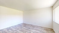 Located at 1233 East Madison Avenue in El Cajon, CA, this single-story 2-bedroom, 2-bathroom home offers a clean, functional layout with a bright and neutral aesthetic throughout. Wood-look flooring flows through the main living areas, complementing the crisp white walls and creating a warm, cohesive feel.

The combined kitchen and living area is well-appointed, featuring white cabinetry, a gas range, dishwasher, and refrigerator. A ceiling fan provides comfort, and the open layout connects the kitchen efficiently to the living space. A large window in the living area overlooks a well-maintained landscaped courtyard, filling the space with natural light.

Both bedrooms are comfortably sized, with the primary bedroom offering a generous footprint. The bedrooms feature soft carpeting and ample closet space with sliding-door wardrobes providing built-in shelving and hanging rods. One bedroom includes a window with courtyard views, adding a pleasant natural element.

The two bathrooms are finished in clean, light tones. One features a wide vanity with under-sink storage, a tri-panel mirror cabinet, and chrome fixtures. The home also includes a dedicated closet for additional storage. Overall, the space presents a tidy, move-in-ready interior suited for practical, comfortable living.
