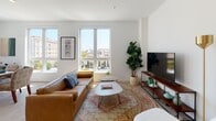 Located at 222 W Sixth St in San Pedro, Los Angeles, this single-floor residence offers a well-designed layout with a contemporary aesthetic throughout. Crisp white walls, light wood-style flooring, and large windows define the interior, creating a bright and airy atmosphere across all rooms.

The living area is generously proportioned, featuring oversized windows that frame views of the surrounding neighborhood, including palm trees and nearby architectural landmarks. Natural light fills the space throughout the day, complementing the clean, modern design. An adjacent dining area benefits from corner windows on two sides, further enhancing the sense of openness and providing additional outdoor views.

The galley-style kitchen is outfitted with dark matte cabinetry, white countertops, white subway tile backsplash, stainless steel appliances, and light wood flooring — a functional and stylish space for cooking and entertaining.

Two bedrooms offer comfortable retreats, each with light-filled windows and neutral finishes. The bathrooms feature wood-toned cabinetry with white countertops, backlit mirrors, and tub-shower combinations with clean tile surrounds.

A well-lit entry corridor, accented by recessed lighting and subtle architectural details, connects the rooms and contributes to the cohesive, modern character of the residence.