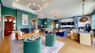 Located at 2460 Walcutt Road in Hilliard, Ohio, this 1,970-square-foot single-floor community space is a masterclass in bold, curated interior design. The grand entrance lobby sets an immediate tone with exposed wood beam ceiling details, gleaming hardwood floors, a sculptural multi-pendant chandelier, and a distinctive reception desk with an artisan wood-panel facade. Deep teal walls and a vibrant Persian-style area rug anchor the welcoming entry hall.

The expansive living room flows seamlessly from the lobby, featuring rich teal walls accented by patterned wallpaper, a classic fireplace, arched doorways, hardwood flooring, and an eclectic mix of seating including leather and velvet sofas. Arcade games and gold wall accents add a playful, social dimension to the space.

A secondary lounge area provides a quieter retreat with plush seating, grasscloth-textured walls, large windows with floor-length drapery, and gallery-style wall art. Adjacent, a dedicated media room offers a large projection screen, plush carpeting, and stylish sputnik chandeliers for an immersive viewing experience.

The kitchen and bar area is a design highlight, featuring dark stone countertops, a sculptural scalloped-detail island, blue zellige tile accents, pendant lighting, and bar-height seating — all framed by large windows overlooking the outdoors.