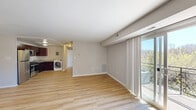 Located at 4445 23rd Pkwy in Temple Hills, Maryland, this one-bedroom, one-bathroom residence offers a well-organized, efficient layout across a single floor. The open living area is bathed in natural light, courtesy of large sliding glass doors that lead to a private balcony overlooking a scenic wooded backdrop. Light-toned hardwood flooring runs throughout the main living space, complementing the neutral, warm-gray walls and clean white trim that give the home a bright, modern feel. The kitchen features dark cabinetry with ample counter space and includes a stainless steel refrigerator, and the in-unit washer is conveniently positioned nearby. The bedroom is a comfortable, well-proportioned room with plush carpeting, a window that brings in natural light, and direct access to a generously sized walk-in closet outfitted with dual hanging rods and shelving on multiple walls. The full bathroom is clean and functional, featuring a tiled tub-shower combination with chrome fixtures. Flush-mount ceiling lighting throughout the home provides consistent illumination, while the entry area offers a practical transition point into the living space. Overall, the residence presents a cohesive, move-in-ready aesthetic with thoughtful storage and comfortable living areas.