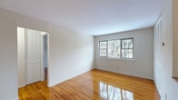 Located at 2 Hazen Court in Wayne, NJ, this well-appointed 2-bedroom, 1-bathroom residence offers a thoughtfully designed single-floor layout. Gleaming hardwood floors extend throughout the living areas and bedrooms, lending warmth and a polished aesthetic to the space. The bright and open living room features large multi-pane windows that invite natural light and offer views of the surrounding neighborhood. The kitchen is equipped with honey-toned wood cabinetry, granite-style countertops, stainless steel refrigerator, and a pass-through counter that connects to the dining area, enhancing the flow between spaces. Tile flooring in the kitchen and dining area provides a clean, practical contrast to the wood floors elsewhere. The primary bedroom is generously sized and includes an expansive wall-to-wall louvered closet, offering ample storage. The second bedroom also features hardwood flooring—laid in a classic parquet pattern—and a large window with outdoor views. The full bathroom is finished with neutral tile surrounds and includes a soaking tub with shower. With five closets total throughout the unit and a functional hallway connecting all rooms, storage and accessibility are key strengths of this residence.