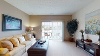 Located at 4333 Parkway Village Dr in Grove City, Ohio, this two-story residence offers a well-organized and comfortable layout across two levels. The living room is a welcoming focal point, featuring neutral-toned walls, plush carpeting, and a textured ceiling. A large sliding glass door floods the space with natural light and opens directly onto a private balcony, ideal for outdoor relaxation. The kitchen is efficiently designed with warm oak cabinetry, stainless steel appliances including a refrigerator, range, microwave, and dishwasher, complemented by light hardwood-style flooring. The upper level hosts multiple bedrooms, each with carpeted floors, ample closet space, and windows that bring in natural light. The primary bedroom features vaulted ceilings, adding a sense of openness, while the secondary bedrooms offer cozy, well-proportioned spaces. The bathroom is outfitted with a wood-tone vanity, light countertops, and hardwood-style flooring. A dedicated in-unit laundry area adds everyday convenience. Throughout the home, consistent warm neutral tones and wood accents create a cohesive and inviting atmosphere.