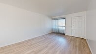 Located in Imperial Beach, California, this 2-bedroom, 1-bathroom single-floor home offers a clean, bright, and functional layout. Light wood-style flooring flows consistently throughout the entire space, lending a cohesive and modern feel.

The combined kitchen and living area forms the heart of the home. The U-shaped kitchen is well-equipped with ample white cabinetry, white countertops, a double-basin sink beneath a window that brings in natural light, a white electric range, and a full-size refrigerator. A peninsula countertop provides a natural divider between the kitchen and the open living area. The living room is generously proportioned, featuring a sliding glass door with vertical blinds that opens to the exterior and allows abundant natural light to fill the space.

Both bedrooms are comfortably sized, bright, and finished with the same light wood-style flooring. Each room includes windows with vertical blinds, providing natural light and outdoor views. The primary bedroom offers a notably spacious footprint.

The full bathroom features a single-sink vanity with a light gray cabinet, a large mirror with overhead lighting, and a full tub-shower combination. Textured ceilings are present throughout, adding subtle architectural character. A hallway connects the main living areas to the bedrooms and bathroom, completing this well-organized and efficiently designed home.