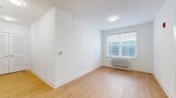 Located at 110 Bergen Tpke in Little Ferry, NJ, this efficiently designed one-bedroom, one-bathroom unit offers a thoughtful layout across a single floor. Warm hardwood-style flooring flows consistently throughout the space, complementing the clean, white walls and crisp baseboards that give the unit a bright, modern feel.

The kitchen is a standout feature, equipped with a full suite of stainless steel appliances including a refrigerator, dishwasher, microwave, and range. Taupe shaker-style cabinetry with contemporary hardware extends to the ceiling, maximizing storage, while light quartz countertops and a stainless steel sink complete the polished look. A stylish pendant light fixture adds a decorative touch above the kitchen area. A set of louvered double doors provides additional storage or closet space nearby.

The bedroom is a well-proportioned, serene space painted in soft gray tones, with natural light entering through a window fitted with blinds. A wall-mounted HVAC unit ensures year-round comfort.

The bathroom is clean and modern, featuring large-format white tile flooring, a glass-enclosed walk-in shower with tile surround, a warm-toned vanity with a white countertop, and a wall-mounted grab bar. The overall ambiance of the unit is fresh, functional, and move-in ready.