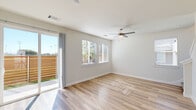 This well-designed two-story home in Denton, TX offers a thoughtful layout spread across two floors. The main level features an open and airy living room with light-toned hardwood-style flooring, a ceiling fan, and large windows alongside a sliding glass door that fills the space with natural light and provides views of the fenced outdoor area. The kitchen is a standout, showcasing two-tone cabinetry with crisp white upper cabinets and bold navy lower cabinets, a white subway tile backsplash, granite countertops, a center island, and stainless steel appliances. A convenient half bath with a pedestal sink and oval mirror completes the main floor. Upstairs, the primary bedroom offers comfortable carpeted flooring, a ceiling fan, and natural light, accompanied by dedicated closet space. The second bedroom mirrors this comfortable feel with carpet, a ceiling fan, and bright windows. The bathrooms are finished with granite vanities and clean, modern fixtures, including a full bath with a glass-enclosed walk-in shower featuring a built-in bench. A laundry area adds everyday practicality. Throughout the home, consistent light wood-style flooring on the main level, neutral wall tones, and modern finishes create a cohesive and inviting atmosphere.