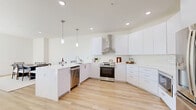 This contemporary apartment, located at 185 Morris Ave in Long Branch, NJ, offers 1230 square feet of thoughtfully designed living space. The open-concept floor plan seamlessly integrates the living room, dining area, and kitchen, creating a spacious and inviting atmosphere. Large windows throughout flood the space with natural light and provide scenic views of the surrounding area.

The apartment features two bedrooms, including a generous 310 square foot primary bedroom, both offering ample closet space and balcony access. Two well-appointed bathrooms complement the bedrooms, with one showcasing a modern vanity and glass-enclosed shower/tub combination.

The kitchen is a highlight, boasting sleek white cabinetry, stainless steel appliances, and ample counter space. Light wood flooring runs throughout the apartment, adding warmth and continuity to the space. The neutral color palette creates a blank canvas for personalization.

Additional features include a dedicated entryway with a console table, recessed lighting, and a mix of carpeted and hardwood floors in different areas. The apartment's layout and amenities make it ideal for comfortable modern living in a prime Long Branch location.