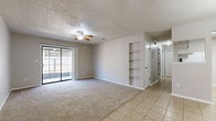 Located in Milton, Florida, this single-story, 2-bedroom, 1-bathroom home offers a practical and well-organized layout. The living room is a comfortable, carpeted space featuring a ceiling fan, built-in wall shelving, and sliding glass doors that open to the patio, allowing natural light to fill the room. Adjacent to the living area, the dining room is finished with light tile flooring and accented by a classic chandelier, with the front entry door visible nearby, framed by a transom window that adds a welcoming touch. The galley-style kitchen is efficiently designed with ample white cabinetry, tile flooring, a double sink, and white appliances including a coil-top range and refrigerator. The primary bedroom is generously sized, featuring plush carpet, a ceiling fan, a closet with sliding doors, and built-in shelving. The second bedroom also offers carpeted flooring, a ceiling fan, and a window that brings in natural light. The bathroom includes a full tub/shower combination with floor-to-ceiling neutral stone-look tile surround. A hallway connects the bedrooms and bathroom. The patio provides an outdoor extension of the living space, completing this straightforward and functional home.