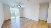 Located at Wesley Place in Indianapolis, Indiana, this single-floor residence offers a clean, contemporary design throughout. The open living area features light hardwood flooring, crisp white walls, and a ceiling fan, with a sliding glass door dressed in vertical blinds that invites natural light and provides outdoor access. The kitchen is thoughtfully appointed with white shaker cabinetry, stainless steel appliances including a refrigerator, range, and microwave, and a central island topped with granite countertops and a double undermount sink — an ideal space for cooking and entertaining. Bedrooms are carpeted for comfort, offering a soft contrast to the hardwood found in the main living areas. One bedroom features a double-door closet, while the primary bedroom connects to a generously sized walk-in closet with built-in shelving. The primary bathroom is well-appointed with a dual-sink granite vanity, white cabinetry, a glass-enclosed shower, and hardwood-style flooring. A dedicated in-unit laundry room provides added convenience with full-size washer and dryer hookups and overhead shelving. Throughout, the space maintains a bright, neutral palette that creates a clean and welcoming atmosphere.