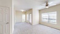 This 1-bedroom, 1-bathroom residence offers a thoughtfully designed single-floor layout that maximizes comfort and functionality. The open living area features neutral-toned carpet, soft cream walls, and abundant natural light streaming through multiple windows fitted with blinds. A ceiling fan adds to the airy feel of the space. French-style doors lead to an outdoor area, further enhancing the sense of openness.

The kitchen is equipped with dark wood cabinetry, light stone-finish countertops, and a full suite of black appliances, including a refrigerator, electric range with microwave, and dishwasher. Wood-look luxury vinyl flooring grounds the space with a warm, contemporary aesthetic.

The bedroom is generously proportioned, featuring plush carpet, a ceiling fan, and a large window with outdoor views. It connects directly to a spacious walk-in closet outfitted with dual hanging rods and built-in shelving, offering ample storage.

The bathroom is finished with the same dark cabinetry as the kitchen, complemented by a marble-look countertop, an under-mount sink, and a well-lit vanity mirror. Wood-look flooring carries through here as well, creating a cohesive design. The overall ambiance is clean, bright, and move-in ready.