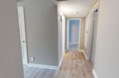 This 900-square-foot, single-floor apartment at 500 Piccadilly Row in Antioch, TN offers a well-designed layout with 2 bedrooms, 2 bathrooms, and 2 hallways. The open-concept living room features light wood-style flooring, a white corner fireplace, and a sliding glass door that leads to a private outdoor space, filling the room with natural light. The adjoining kitchen is equipped with white cabinetry, white countertops, stainless steel appliances including a refrigerator, electric range, and dishwasher, complemented by a functional breakfast bar. Both bedrooms feature soft carpet flooring, neutral taupe walls, and bifold closets with built-in hanging rods. The primary bedroom measures 200 square feet, offering a spacious retreat. The two bathrooms include white vanities with stone-speckled countertops and brushed nickel fixtures; one features a shower/tub combo. Textured ceilings are present throughout the unit. The overall aesthetic is clean and neutral, with consistent warm-toned walls and white trim creating a cohesive, move-in-ready atmosphere throughout the home.