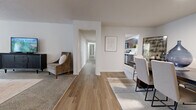 This well-appointed single-story home offers a thoughtfully designed layout across a generous footprint, accommodating four bedrooms, two bathrooms, and a range of functional living spaces. The interior features a clean, neutral palette with white walls throughout, complemented by wood-look plank flooring in the main living areas and plush carpet in the bedrooms.

Two separate living areas provide flexible use of space—one serves as a comfortable lounge with ample room for seating and entertainment, while the other functions as a more intimate gathering area. The kitchen is equipped with stainless steel appliances, granite-style countertops, dark cabinetry, and a peninsula that opens toward the adjacent dining room, which features wood-look flooring and room for a full dining set.

A central hallway connects the four bedrooms, each finished with carpet and sliding or hinged closet doors. The spacious primary bedroom includes a dedicated walk-in closet with wire shelving. Both bathrooms feature wood-look flooring and dark vanity cabinetry with stone-look counters. A dedicated laundry room houses a full-size washer and dryer. The textured ceilings and consistent finishes throughout lend the home a cohesive, modern feel.