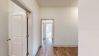 Located in Brookhaven, GA, this well-appointed single-floor residence offers three bedrooms, two bathrooms, and a thoughtfully designed layout that maximizes comfort and functionality. The open-concept kitchen is a standout feature, showcasing rich dark cabinetry, granite countertops, stainless steel appliances, and a large center island with pendant lighting — all complemented by abundant natural light streaming through large windows overlooking mature greenery. Hardwood-style flooring flows throughout the main living and hallway areas, lending a warm, cohesive aesthetic. The hallways connect the spaces efficiently, providing a clean and organized flow. The bedrooms are carpeted for comfort, each featuring large windows or sliding glass doors that frame lush tree canopy views, filling the rooms with natural light. The spacious primary bedroom includes a generously sized walk-in closet with built-in wire shelving for ample storage. The bathrooms are finished with dark wood cabinetry, granite vanities, and tile-surround soaking tubs with shower fixtures. Three closets throughout the home provide excellent storage capacity. The overall ambiance is clean, modern, and bright, with a neutral color palette that creates a calm and inviting atmosphere throughout.