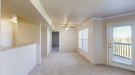 Located at 2276 Castlegate Dr N in Castle Rock, CO, this one-bedroom, one-bathroom residence offers a thoughtfully organized single-floor layout. The living room is a standout space, featuring crown molding, a ceiling fan with light kit, soft carpeting, and a tile-surround fireplace that serves as a focal point. Large windows dressed with vertical blinds flood the room with natural light, while a glass door opens to a private balcony overlooking lush greenery. The open layout includes a half-wall pass-through that connects the living area to the kitchen, enhancing the sense of openness. The galley-style kitchen is equipped with white cabinetry accented by wood-tone trim, ample counter space, a full suite of white appliances including a refrigerator, dishwasher, and electric range, and durable wood-look flooring. The bedroom is a comfortable retreat with plush carpet, a large window with outdoor views, and direct access to both a closet and the full bathroom. The bathroom features wood-look flooring, a single vanity, and a tiled shower-tub combination. Crown molding and a neutral color palette throughout lend the space a cohesive, clean aesthetic.