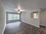 Located at 2255 Satellite Blvd in Duluth, Georgia, this single-floor residence offers a thoughtfully designed layout that balances functionality and modern style. The open-concept living and dining area is finished with rich hardwood-style flooring that extends throughout the main living spaces, creating a warm and cohesive aesthetic. Neutral-toned walls and textured ceilings complement the clean architectural lines throughout.

The kitchen is a standout feature, boasting dark espresso cabinetry, granite countertops with subtle veining, a peninsula with a built-in sink ideal for casual dining or meal prep, and a full suite of stainless steel appliances including a gas range, microwave, and refrigerator. A dedicated laundry area is accessible directly from the kitchen corridor.

The bedrooms are carpeted for added comfort, with one room featuring a ceiling fan, a window with natural light, and ample space. Additional bedrooms include louvered closet doors, offering practical storage solutions. The bathroom is finished with matching granite countertops, dark wood cabinetry, a large vanity mirror, and a shower-tub combination, maintaining the upscale finishes seen throughout the home. Overall, the space presents a clean, modern interior well-suited for comfortable everyday living.