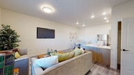 This well-appointed single-story residence at 2000 N 10th St in El Centro, California offers a thoughtfully designed layout that balances comfort and functionality. The open-concept living and dining area is anchored by a bright, airy atmosphere with recessed lighting and durable wood-look flooring throughout. The living room accommodates generous seating, a wall-mounted TV, and natural light from a large window with blinds. Adjacent to it, a dedicated dining nook features a round white marble-top table surrounded by tufted chairs, accented by a curated gallery wall. The contemporary kitchen is outfitted with light wood cabinetry, quartz countertops, a tiled backsplash, stainless steel appliances including a gas range, dishwasher, and microwave, along with a kitchen island for added workspace. Both bedrooms are carpeted and include ceiling fans, wall-mounted TVs, and windows with blinds. The primary bedroom benefits from a spacious walk-in closet with built-in shelving. Each bathroom is finished with light wood vanities, white quartz counters, wood-look flooring, and a shower-tub combination. The overall aesthetic is clean and modern, presenting a cohesive and move-in ready living environment.