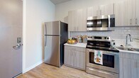 Located at 229 Meeting Street in the heart of Charleston, SC, this thoughtfully designed single-floor studio offers a functional and stylish living experience. The open-concept layout seamlessly connects the living, sleeping, and dining areas, all unified by warm hardwood-style flooring that runs throughout the space.

The kitchen is a standout feature, equipped with stainless steel appliances including a full-size refrigerator, range with over-the-range microwave, and dishwasher. Contemporary light wood cabinetry pairs with a white subway tile backsplash and clean countertops to create a sleek, modern aesthetic. A small dining area with bar-height seating sits just adjacent, making efficient use of the available space.

The living and sleeping area is bright and airy, benefiting from large windows fitted with blinds that allow ample natural light to filter in. A closet with louvered doors provides practical storage within the main room.

The bathroom is well-appointed with a wood-toned vanity topped with a granite-style countertop, a framed mirror, and a tub-shower combination. Neutral tile flooring and soft lighting contribute to a clean, polished feel.

Throughout the unit, a neutral color palette and modern fixtures create a cohesive, contemporary atmosphere ideally suited to Charleston's vibrant urban lifestyle.