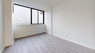 Located at 300 Antibes Dr in North York, Toronto, this well-appointed 2-bedroom, 2-bathroom unit offers a clean, modern aesthetic across a thoughtfully organized single-floor layout. Light wood-style plank flooring runs consistently throughout the space, complementing the crisp white walls and bright, neutral palette that define the unit's interior character.

The living room is an open, airy space featuring large floor-to-ceiling sliding glass doors that lead to a private balcony, offering expansive outdoor views of the surrounding cityscape. Natural light flows generously into the room, enhancing its spacious feel.

The kitchen is efficiently designed in a galley configuration, outfitted with white cabinetry, dark countertops, subway tile backsplash, stainless steel appliances, and recessed lighting. A window above the lower cabinetry brings in additional natural light.

The primary bedroom is generously proportioned, with a large window framing city views. The second bedroom is also well-sized and bright, with access to a full bathroom. Two hallways connect the rooms and include a closet for added storage convenience.

Both bathrooms are finished in white, featuring mosaic tile flooring. One bathroom includes a full soaking tub with white tile surround, while the other offers a vanity with under-cabinet storage and a wall mirror with a window above.