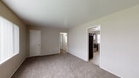 This single-floor residence offers a practical and comfortable layout designed for everyday living. The living area serves as the heart of the home, featuring neutral-toned carpet, a large window with vertical blinds that invites ample natural light, and a closet for convenient storage. An open doorway connects the living space directly to the kitchen, creating a natural flow throughout the common areas.

The kitchen is well-appointed with rich, dark wood cabinetry, dark granite-style countertops, and a tile backsplash. Stainless steel appliances — including a range, dishwasher, and refrigerator — provide a modern, functional touch, while tile flooring adds durability and ease of maintenance.

The bedrooms are carpeted and finished in soft, neutral tones. One bedroom benefits from dual windows that frame outdoor greenery, filling the room with natural light. A second bedroom includes its own closet and a window with blinds. Both rooms offer a calm, understated atmosphere well-suited for rest or work.

The bathroom features tile flooring, a tub-shower combination with full tile surround, a vanity with sink, and a window that provides natural ventilation and light. The consistent use of neutral colors and clean finishes throughout the space creates a cohesive, move-in-ready environment.