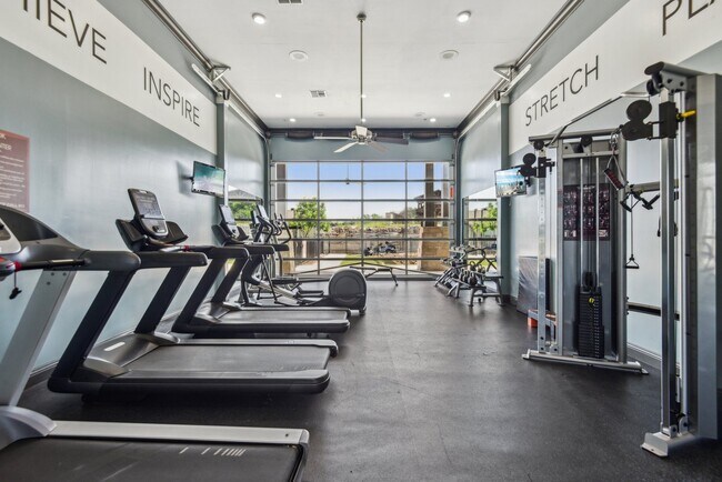 Amplio gimnasio con cintas de correr, pesas libres y mucho más en Overlook at Stone Oak Park Apartments, San Antonio - Overlook at Stone Oak Park Apartments
